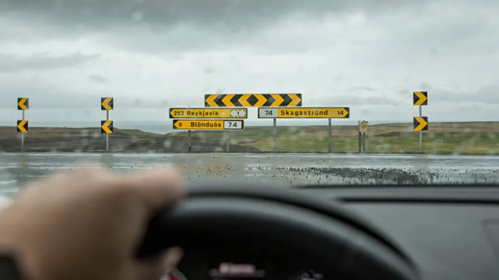 Rain and weather driving test questions guide showing wet road conditions, driver handbook, and safe driving techniques in bad weather