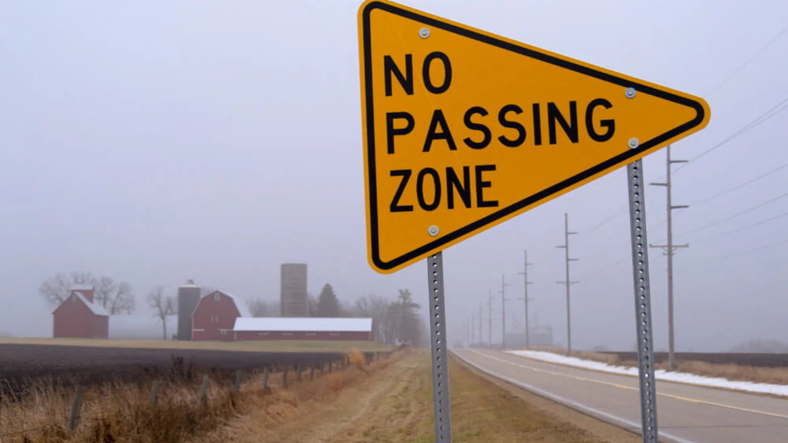 No Passing Zone traffic sign on a rural highway warning drivers that passing is prohibited due to limited visibility and road safety concerns